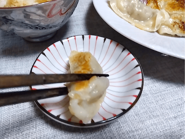 大阪王将の羽根つきスタミナ肉餃子を塩につける画像